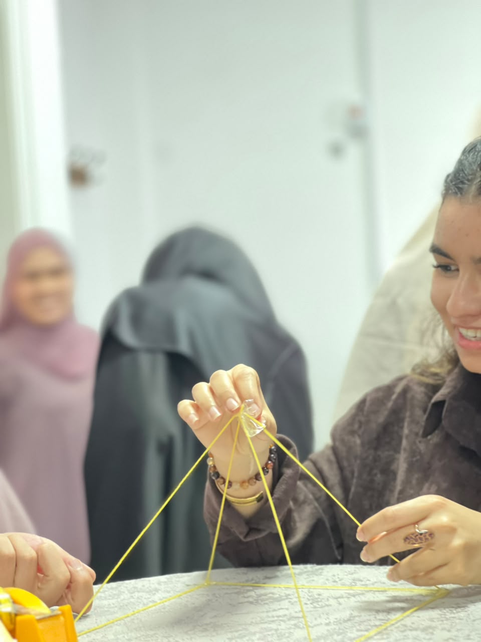 مشاركة تبني برجا من المعكرونة خلال نشاط لبناء روح الفريق